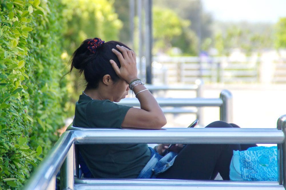 woman sitting on a bench and feeling shame
